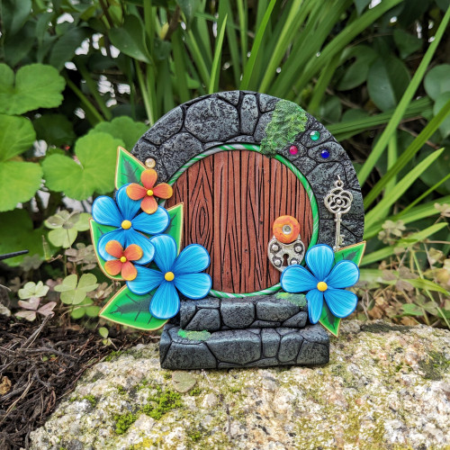 Puerta de Hobbit con flores azules y...