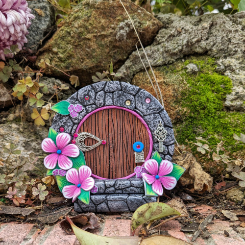 Puerta de Hobbit con flores rosa